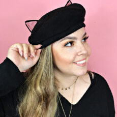 Woman wearing cat eared beret hat looking to side