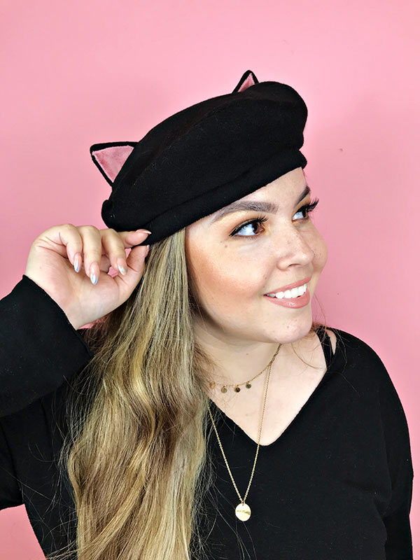 Woman wearing cat eared beret hat looking to side