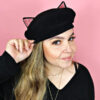 Woman wearing cat eared beret hat looking on