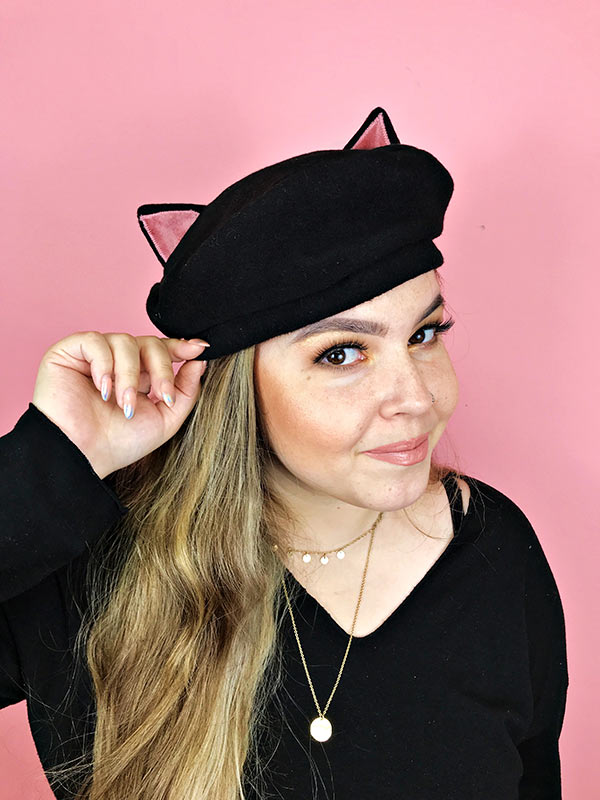 Woman wearing cat eared beret hat looking on