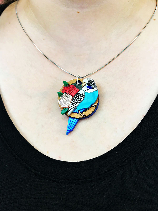 Person wearing Budgie parrot necklace close up