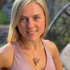woman looking at camera wearing orange cat necklace