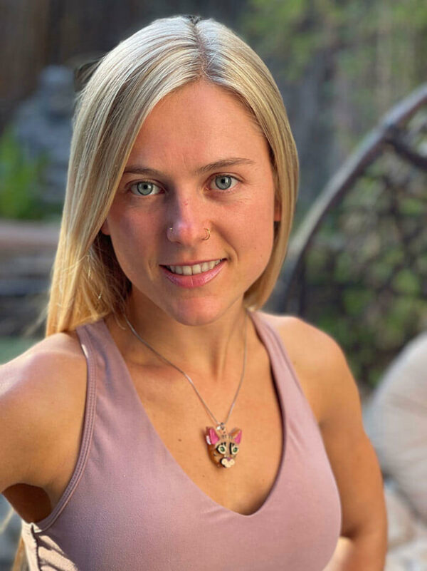 woman looking at camera wearing orange cat necklace